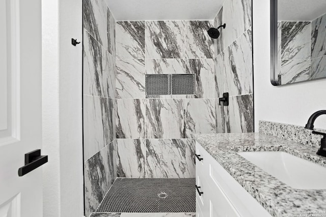 bathroom featuring vanity and a tile shower