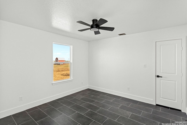 unfurnished room featuring ceiling fan and a textured ceiling