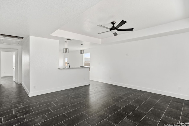 unfurnished living room featuring ceiling fan, a textured ceiling, and dark hardwood / wood-style floors