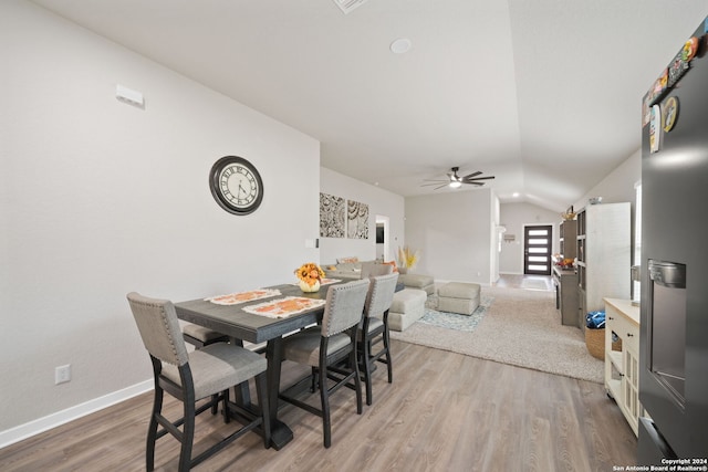 dining room with ceiling fan, vaulted ceiling, and hardwood / wood-style floors