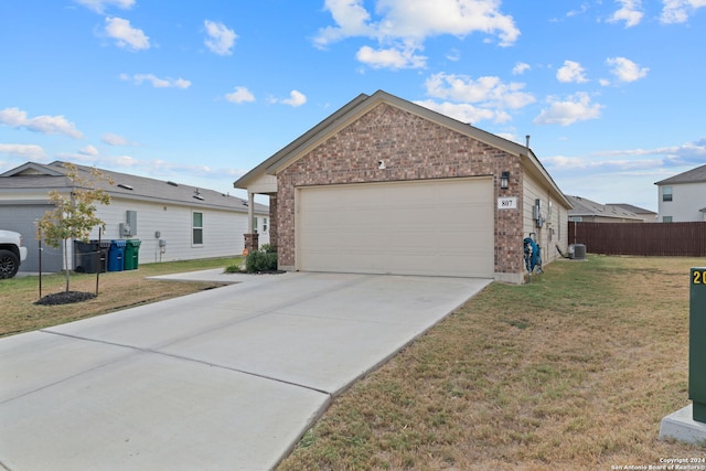 view of front of property featuring central air condition unit, a front yard, and a garage