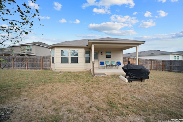 back of house with a patio and a lawn