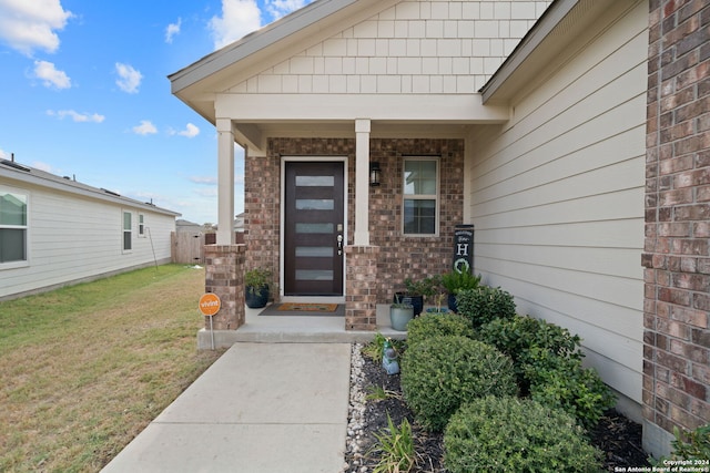 property entrance with a lawn