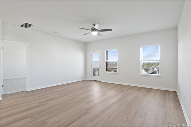 empty room with ceiling fan and light hardwood / wood-style flooring