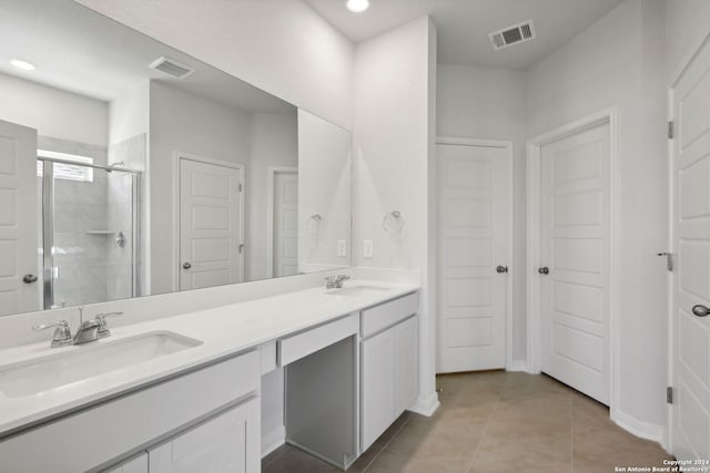 bathroom featuring tile patterned floors, vanity, and a shower with door