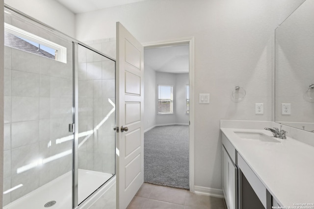 bathroom with tile patterned flooring, vanity, and walk in shower