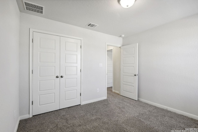 unfurnished bedroom featuring carpet flooring and a closet