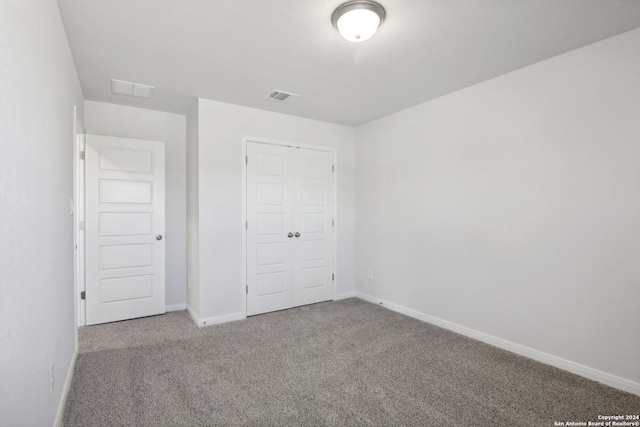 unfurnished bedroom featuring carpet flooring and a closet