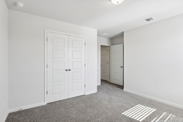 unfurnished bedroom featuring carpet flooring and a closet