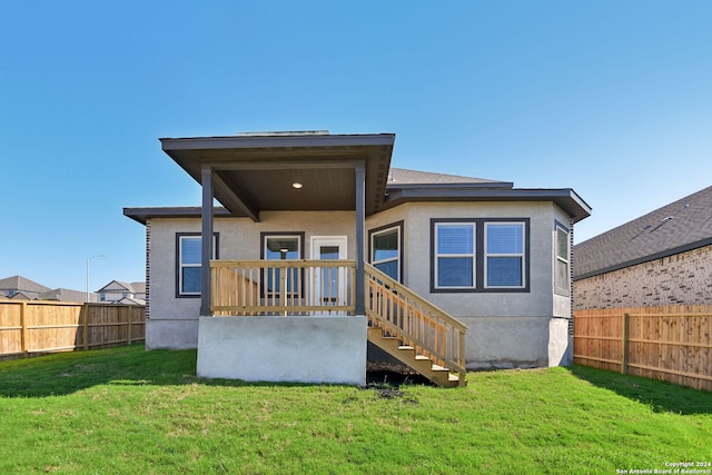 rear view of house featuring a lawn