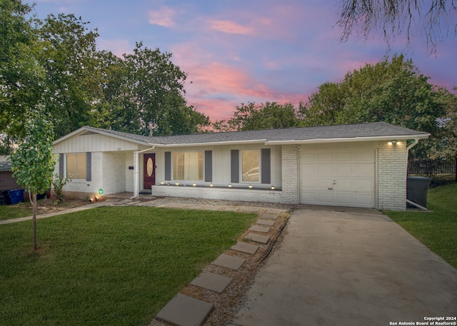 single story home featuring a yard and a garage