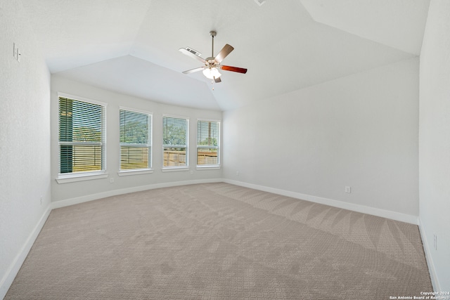 empty room featuring light carpet, vaulted ceiling, and ceiling fan