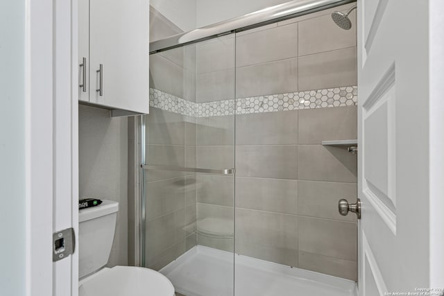 bathroom featuring toilet and an enclosed shower