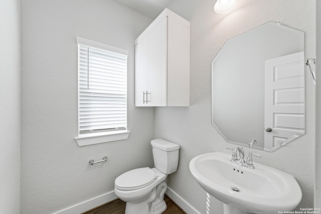 bathroom featuring toilet, hardwood / wood-style floors, and sink