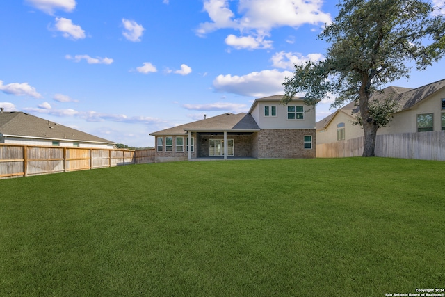 rear view of property featuring a patio area and a yard