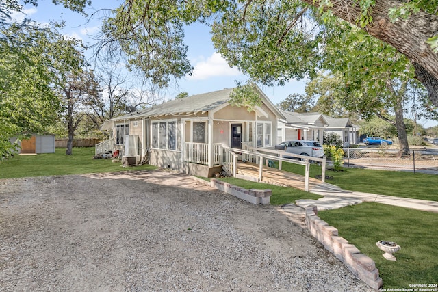 view of front of house with a shed and a front lawn