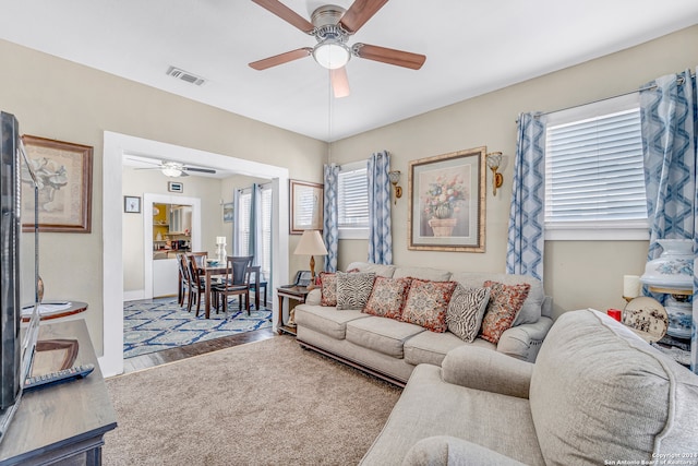 living room featuring ceiling fan, hardwood / wood-style flooring, and plenty of natural light