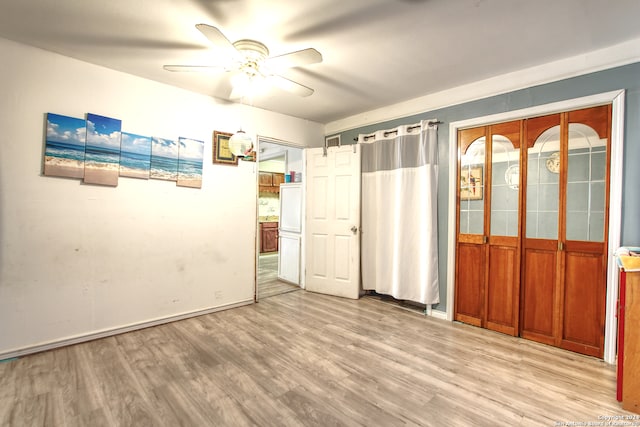 empty room with light wood-type flooring and ceiling fan