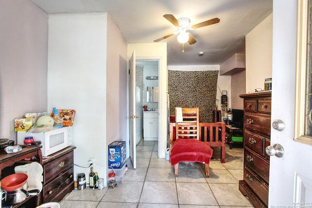 interior space with ensuite bathroom, ceiling fan, and light tile patterned floors