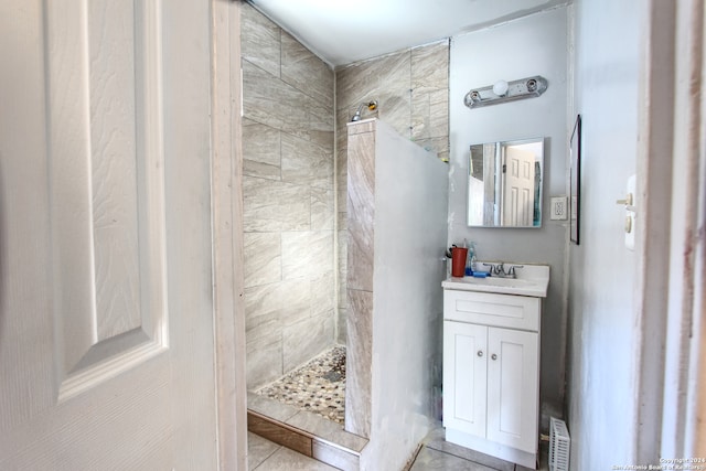 bathroom with vanity, tiled shower, and tile patterned flooring