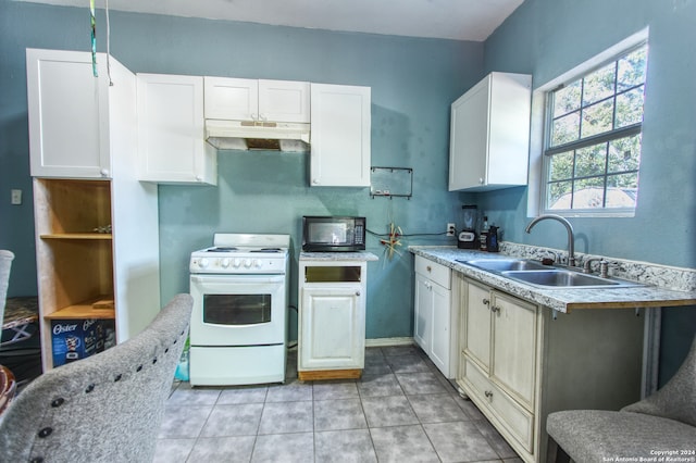 kitchen with light tile patterned flooring, white cabinets, gas range gas stove, and sink