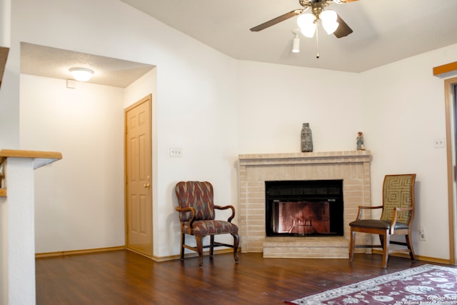 living area with dark hardwood / wood-style floors, a fireplace, and ceiling fan