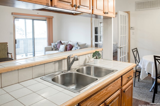 kitchen with tile countertops, sink, and hardwood / wood-style flooring