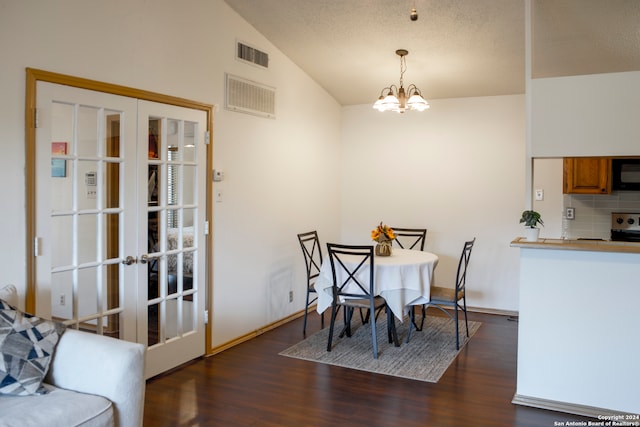 dining room featuring french doors, a textured ceiling, dark hardwood / wood-style flooring, vaulted ceiling, and a chandelier