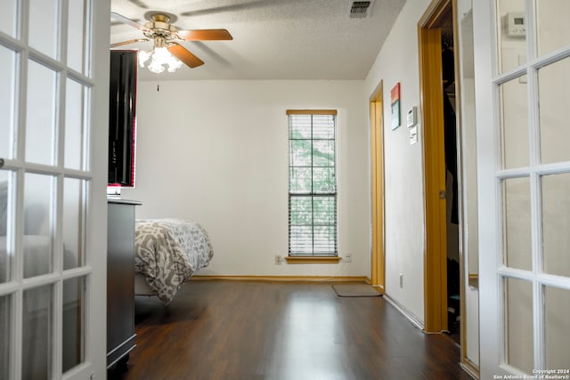 interior space featuring ceiling fan, a textured ceiling, and dark hardwood / wood-style flooring