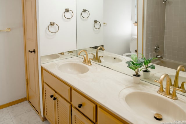 full bathroom featuring tiled shower / bath, vanity, toilet, and tile patterned floors