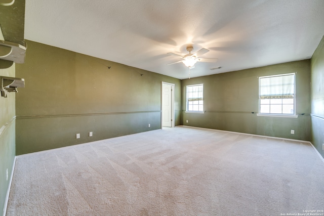 carpeted empty room featuring a textured ceiling and ceiling fan