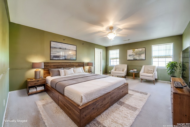 carpeted bedroom featuring multiple windows and ceiling fan