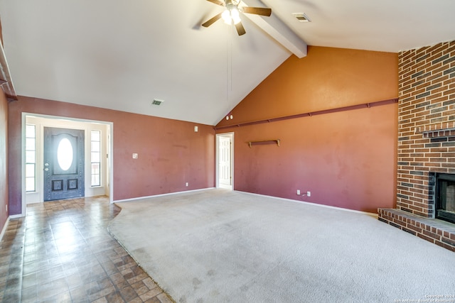 unfurnished living room with a brick fireplace, carpet flooring, high vaulted ceiling, beamed ceiling, and ceiling fan