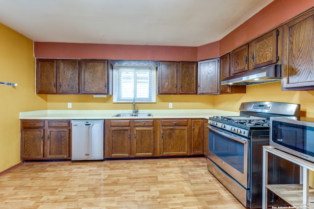 kitchen featuring appliances with stainless steel finishes, sink, and light wood-type flooring