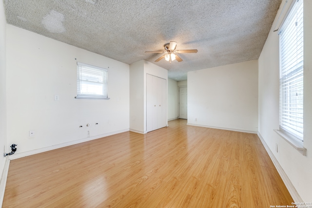 spare room featuring light hardwood / wood-style flooring, a textured ceiling, and ceiling fan