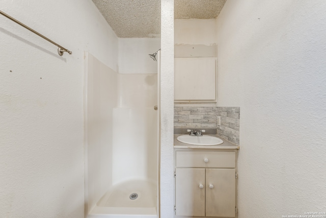 bathroom featuring vanity, decorative backsplash, shower / tub combination, and a textured ceiling