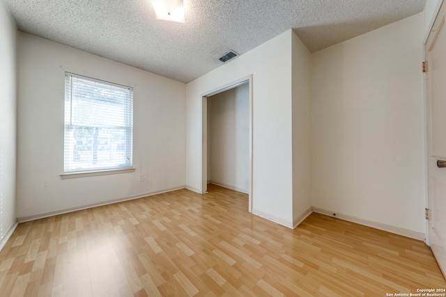 unfurnished bedroom featuring light hardwood / wood-style floors and a textured ceiling