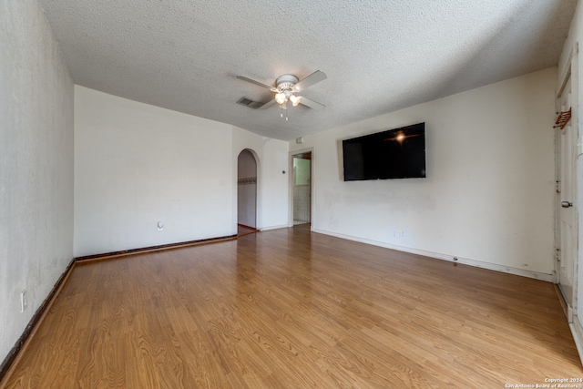 spare room with ceiling fan, a textured ceiling, and light wood-type flooring