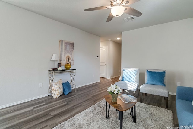 living area featuring dark wood-type flooring and ceiling fan