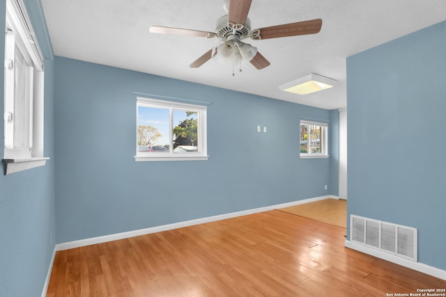 empty room featuring light hardwood / wood-style flooring, a healthy amount of sunlight, and ceiling fan