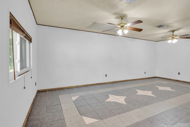 empty room featuring ceiling fan, a textured ceiling, and light tile patterned floors