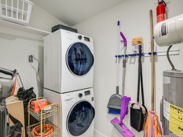 laundry area featuring electric water heater and stacked washer and dryer