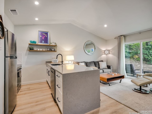 kitchen with white cabinetry, stainless steel appliances, lofted ceiling, and light wood-type flooring