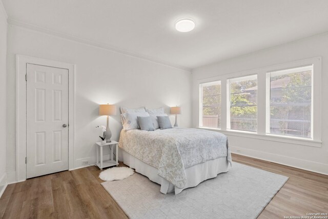 bedroom with crown molding and hardwood / wood-style floors