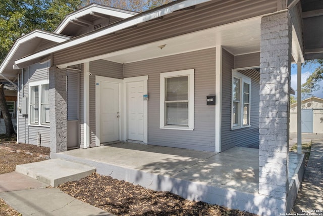 view of exterior entry with a porch