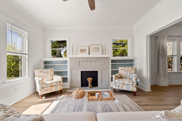 living room with crown molding, hardwood / wood-style flooring, a fireplace, and ceiling fan