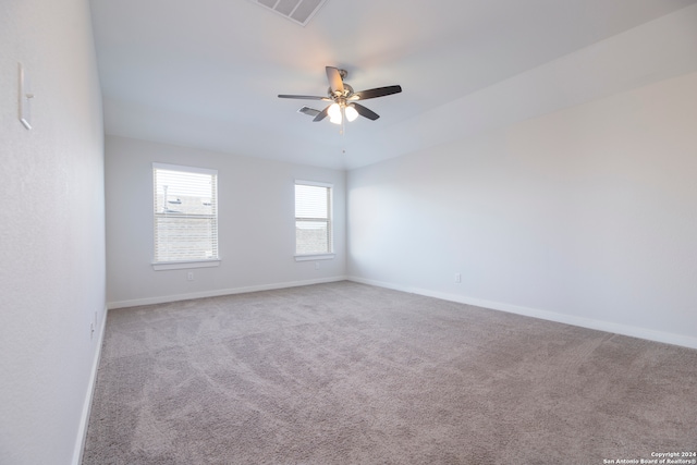 carpeted spare room featuring ceiling fan