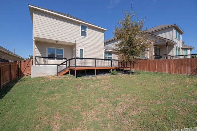 rear view of property with a deck and a lawn