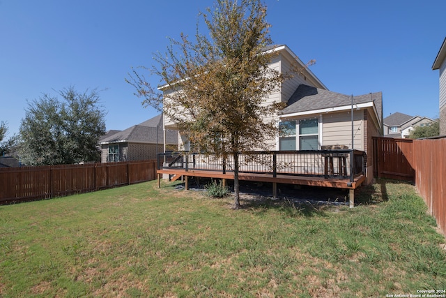 rear view of property featuring a yard and a deck