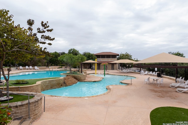 view of pool with a patio, pool water feature, and a gazebo